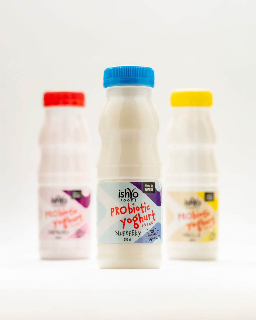 An Ishyo Foods quality inspector beside stacked crates of packaged yoghurt